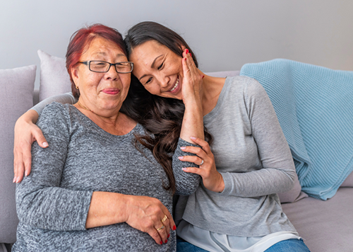 Image of daughter caring for a parent or spouse sitting on the sofa